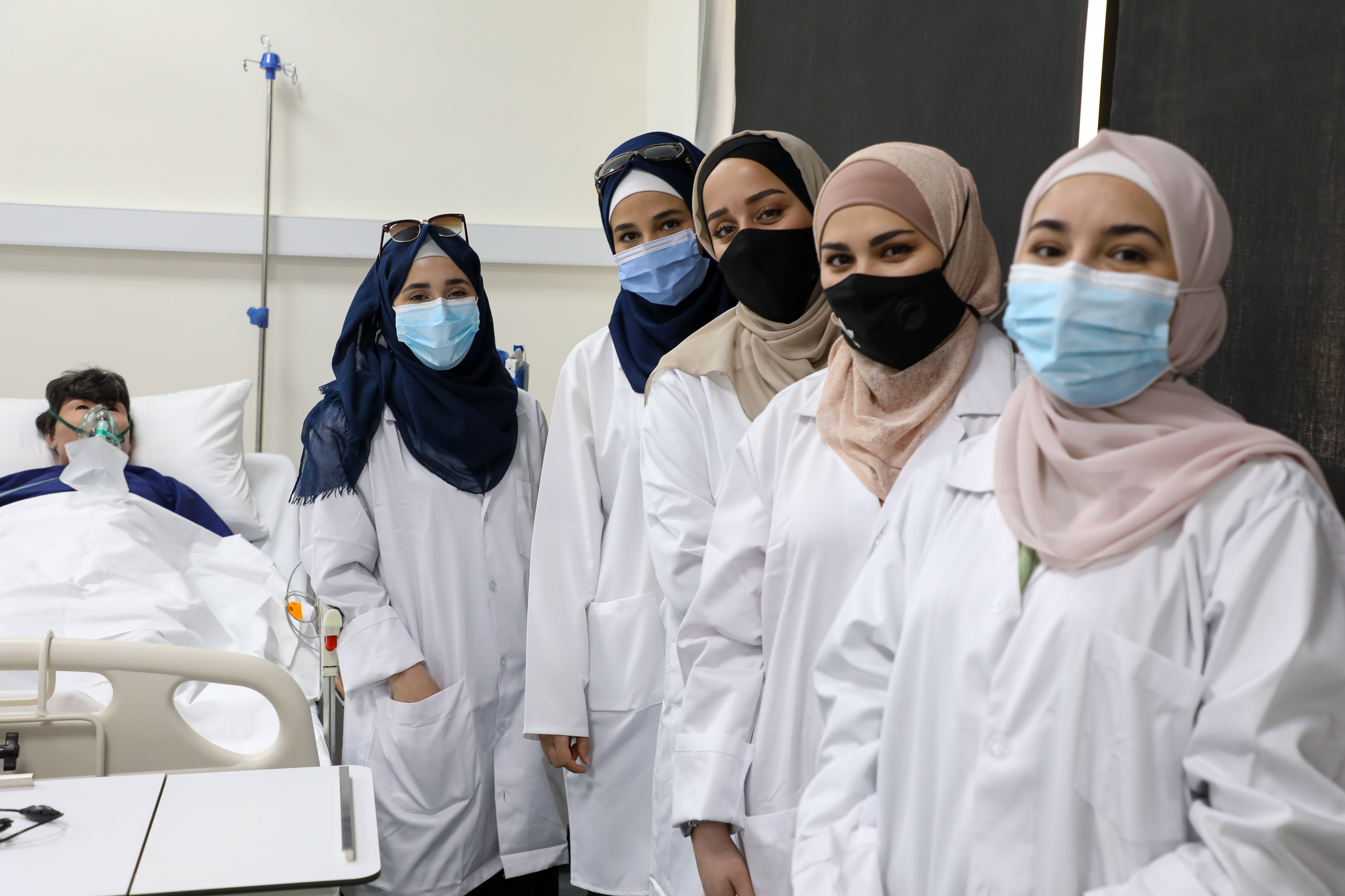 Group of nurses look at camera. Syrian refugee students study nursing in Jordan.