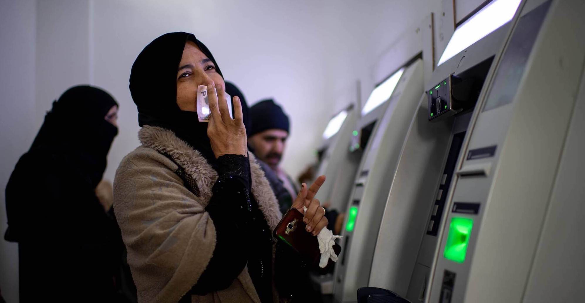 Woman receives monthly payment through UNHCR's cash assistance program