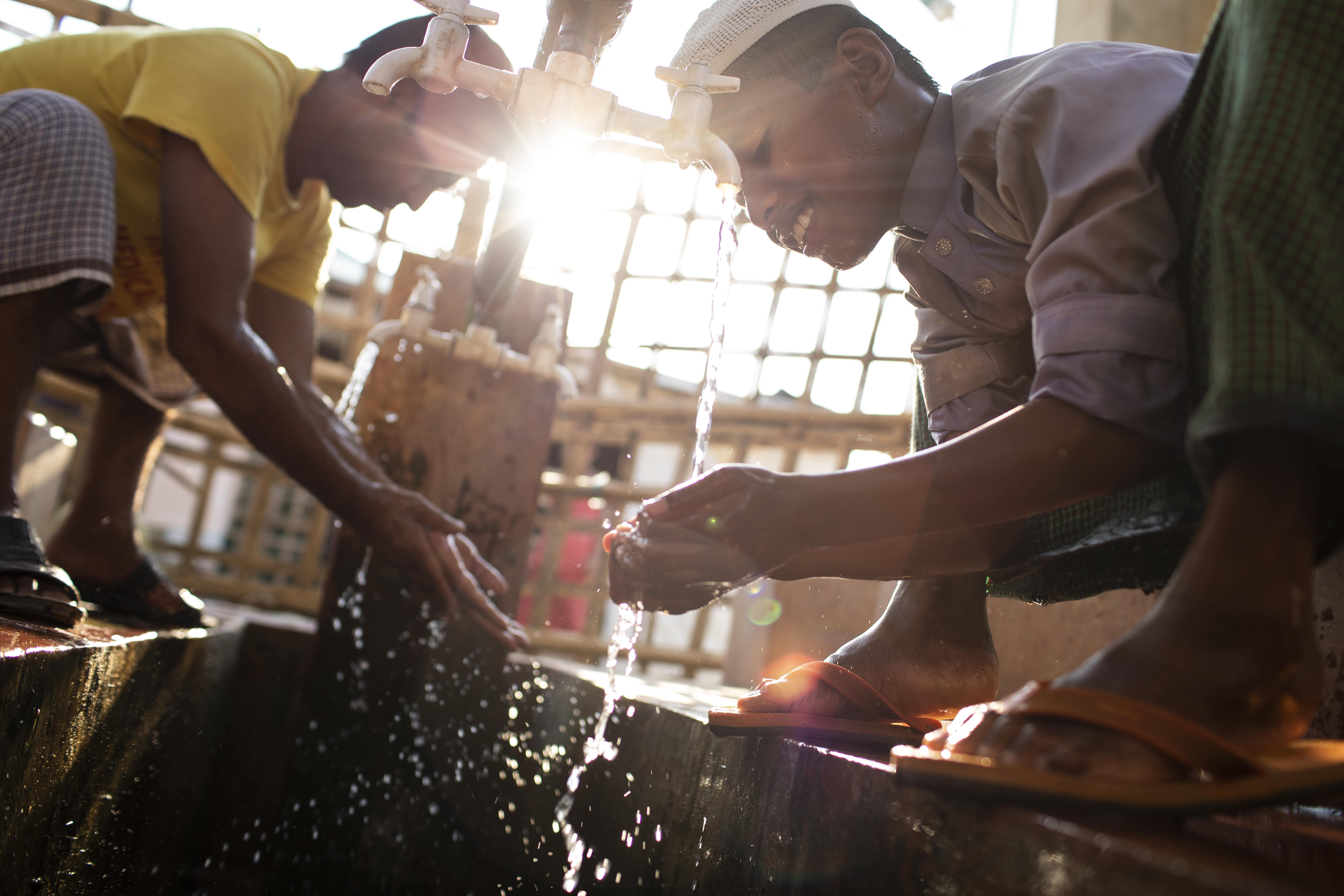 A young Rohingya refugee from Myanmar makes wudhu outside a mosque in the Kutupalong Refugee Camp, Bangladesh. ; Under-Secretary-General for Humanitarian Affairs and Emergency Relief Coordinator Mark Lowcock, Director General of the International Organization for Migration António Vitorino, and UN High Commissioner for Refugees Filippo Grandi visited refugee settlements in Cox’s Bazar in late-April 2019.