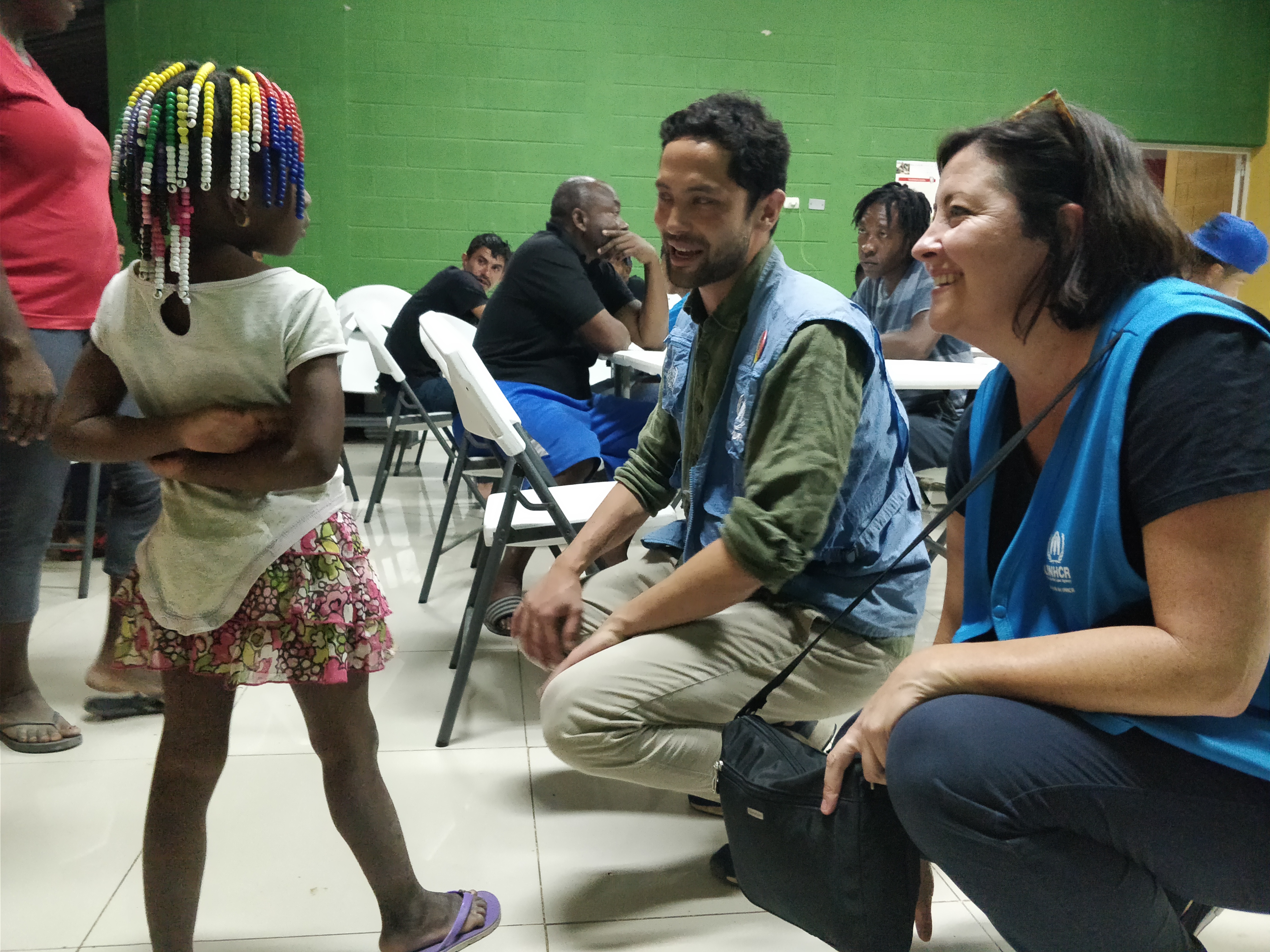 A young child speaks to UNHCR worker and Trudi Mitchell at Guatemala migrant shelter 