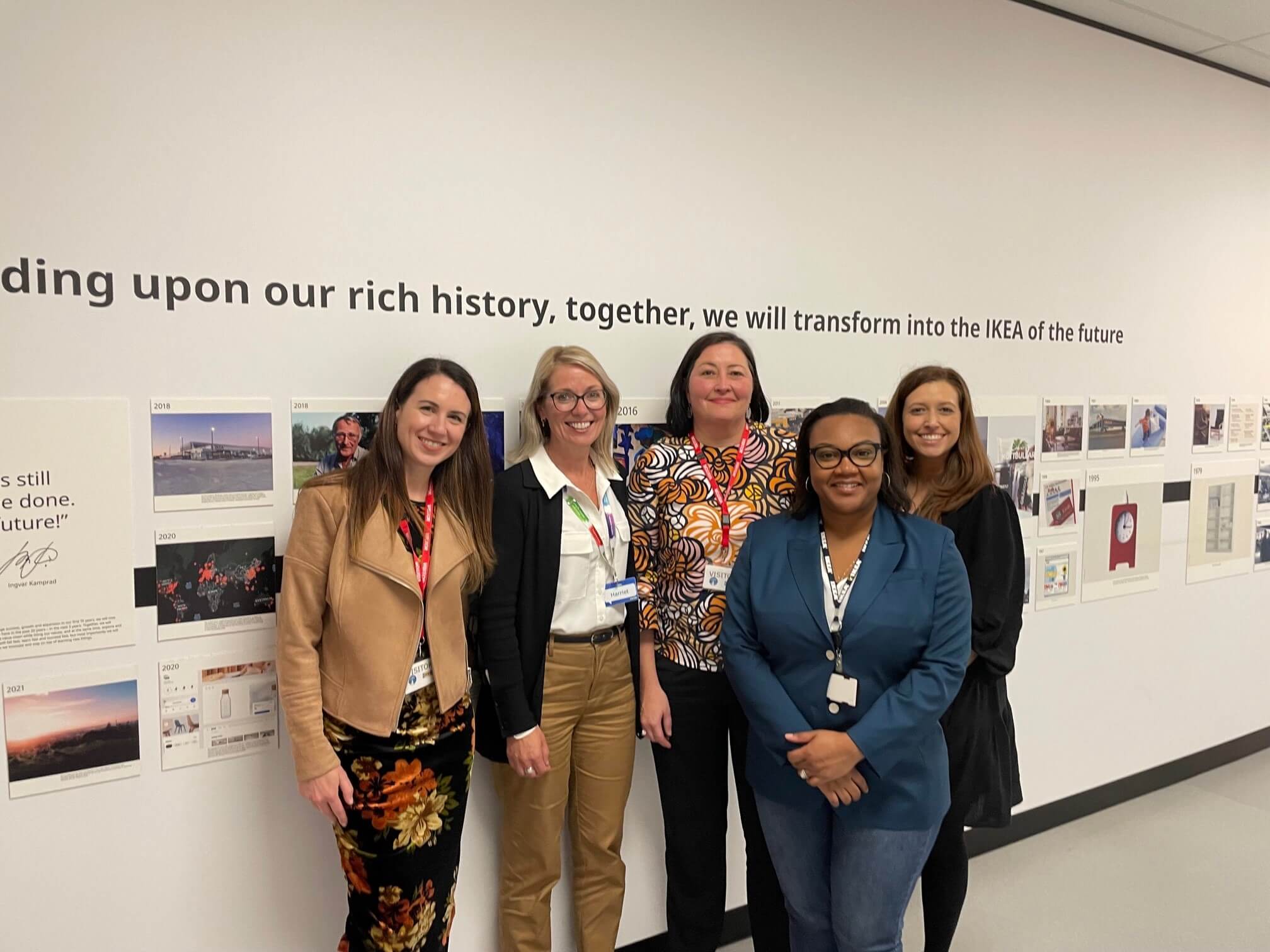 A group of women stand in front of a photo wall at IKEA