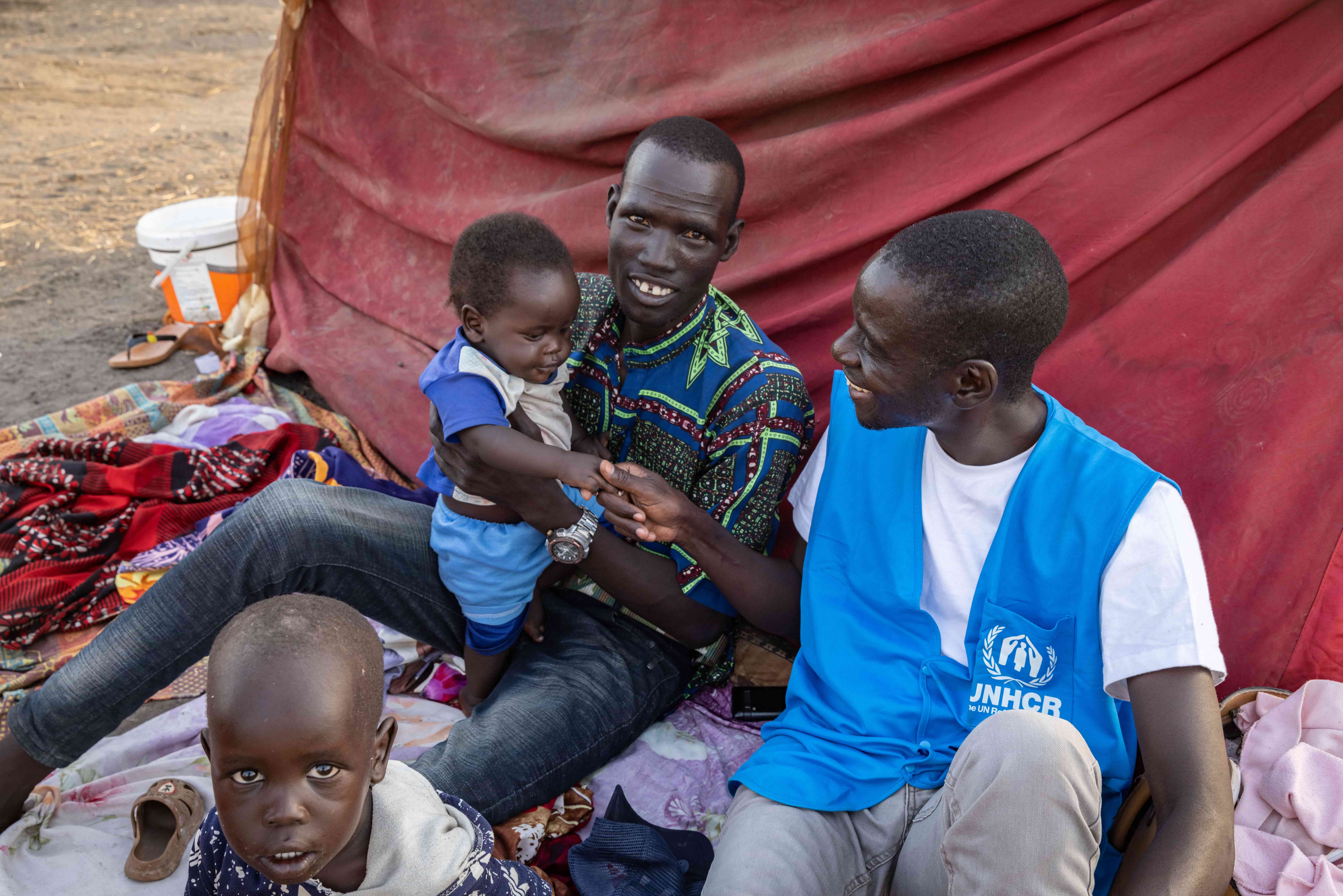  UNHCR Protection Officer Loku James speaks with refugee families at the UNHCR transit centre in Renk, South Sudan. 