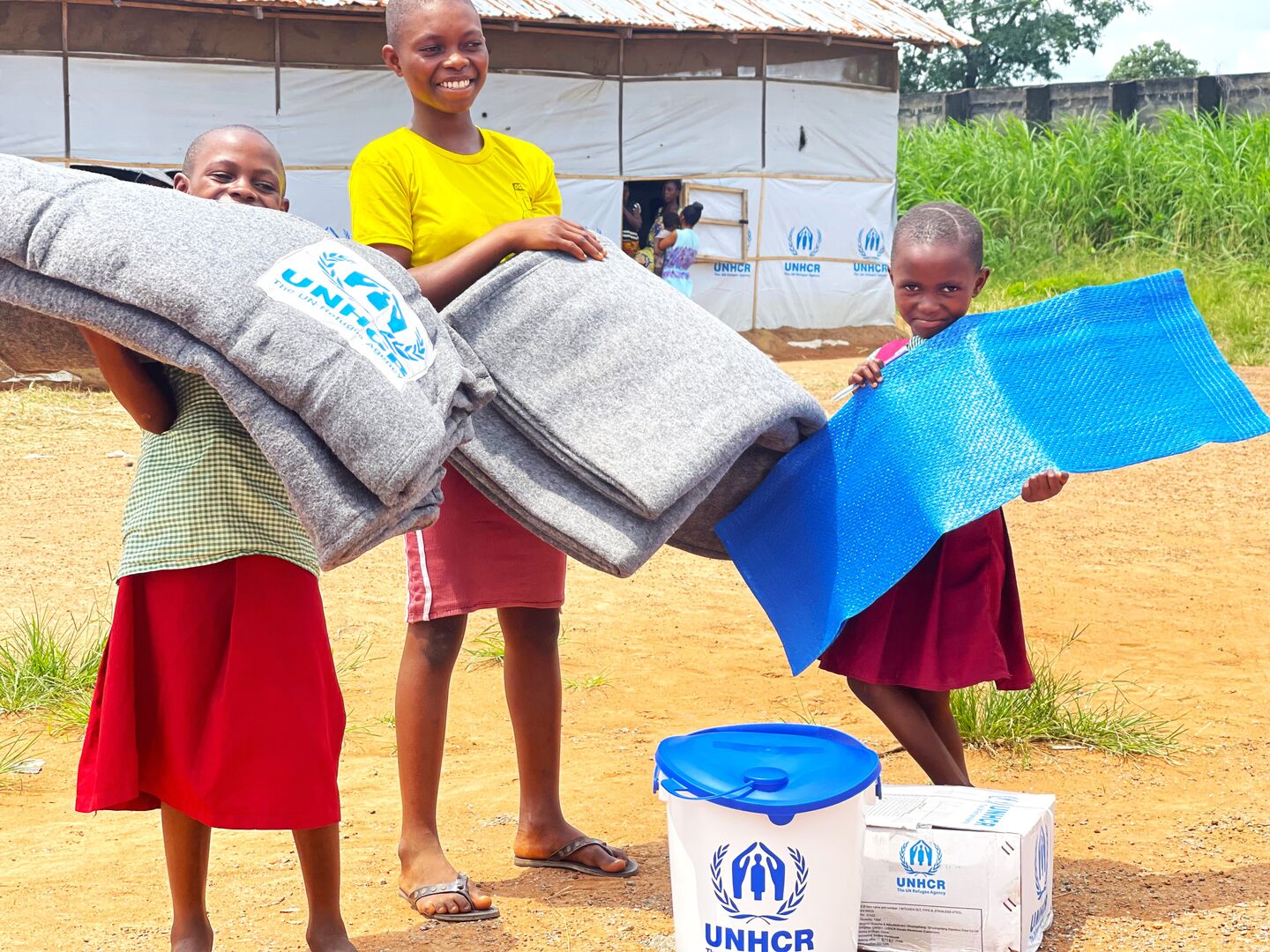 Cameroonian refugee family receive relief supplies including blankets, bucket, kitchen set and sleeping mats to help improve their living standard in Ukende refugee settlement.