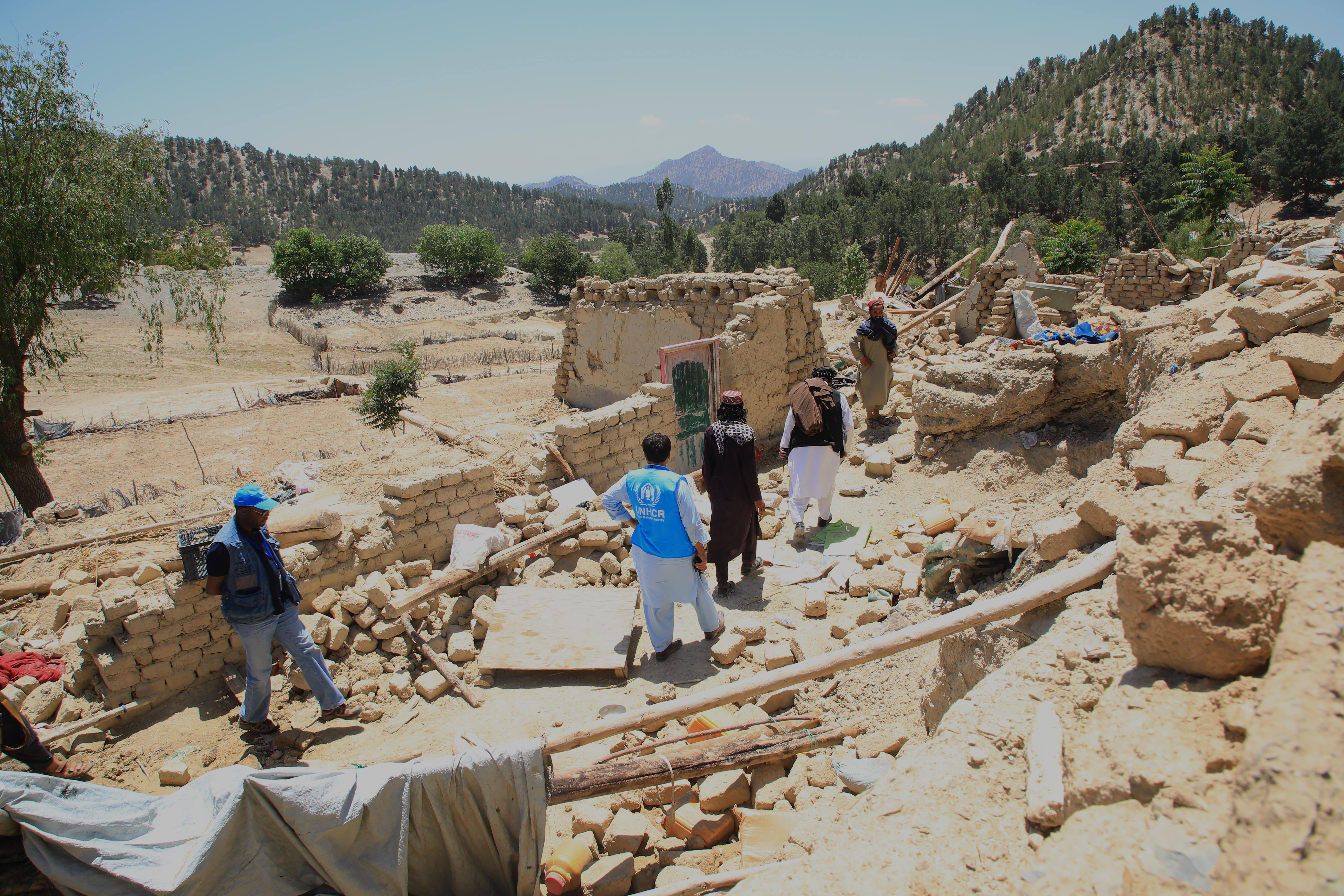 A UNHCR earthquake assessment team walks through the rubble following an earthquake in Spera District, Khost Province. 