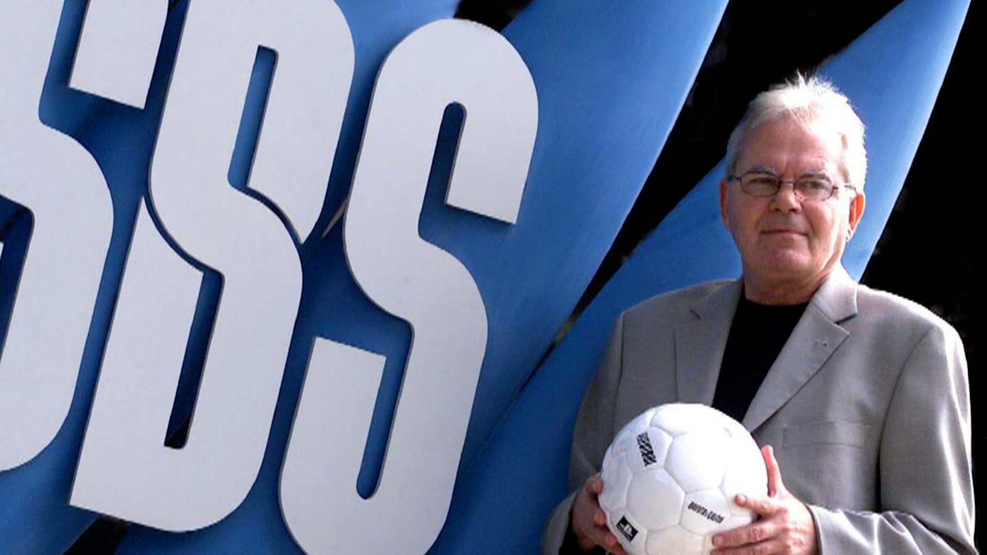 Les Murray in front of SBS sign. Australia for UNHCR award for refugee recognition.
