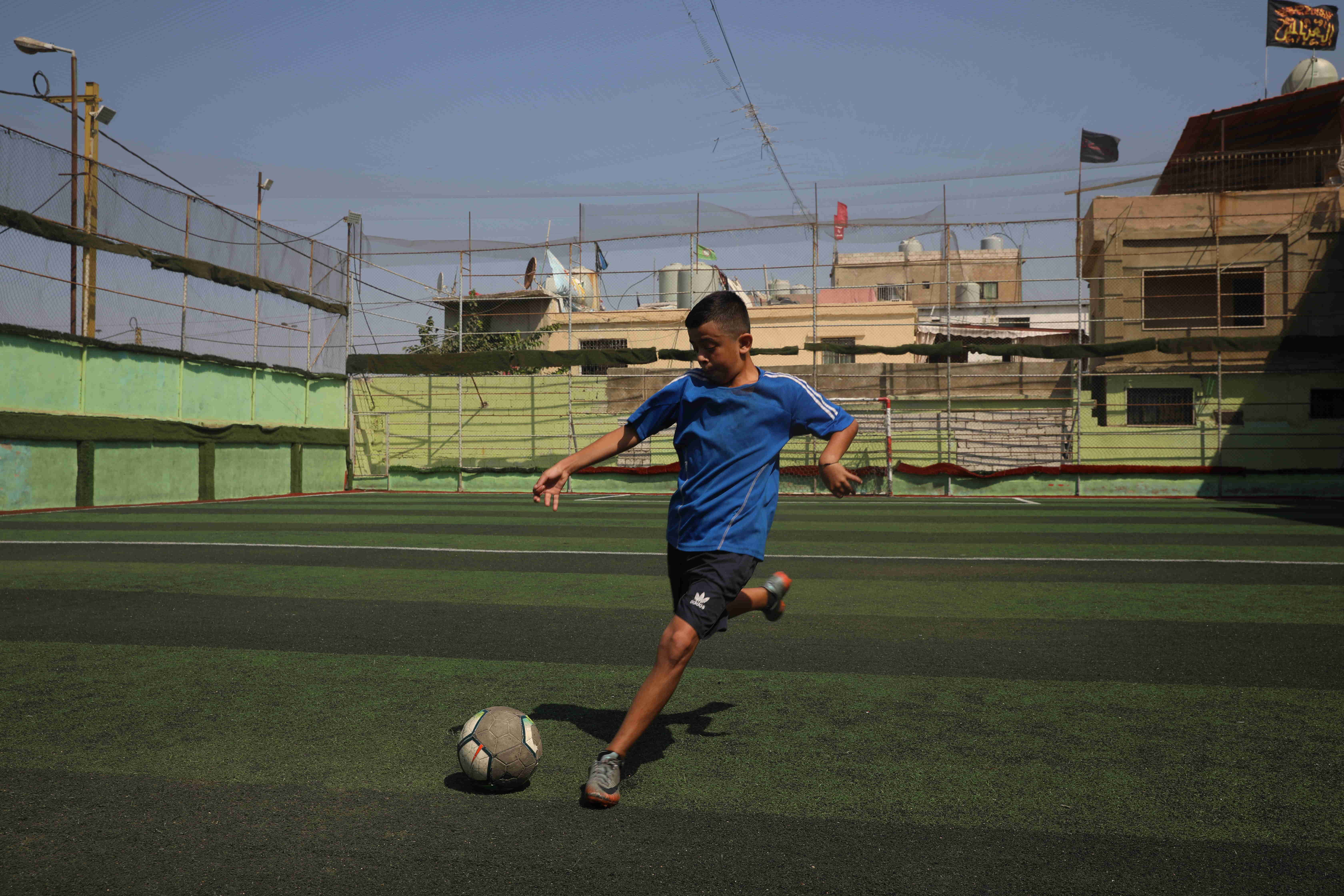 Syrian refugee, Gaith, 13, trains on the pitch at his local youth club in Beirut. ; Thirteen-year-old Gaith dreams of becoming a famous footballer and is ecstatic about moving to the city of his dream club, Real Madrid.