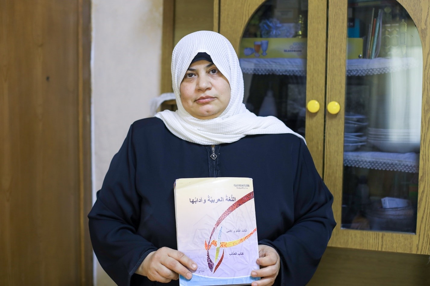 Eman, Syrian refugee in Jordan holds a book